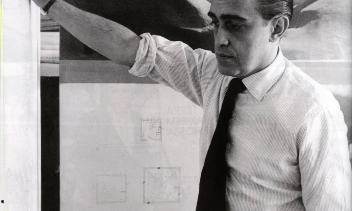 Oscar Niemeyer em seu ateliê, diante de plantas arquitetônicas