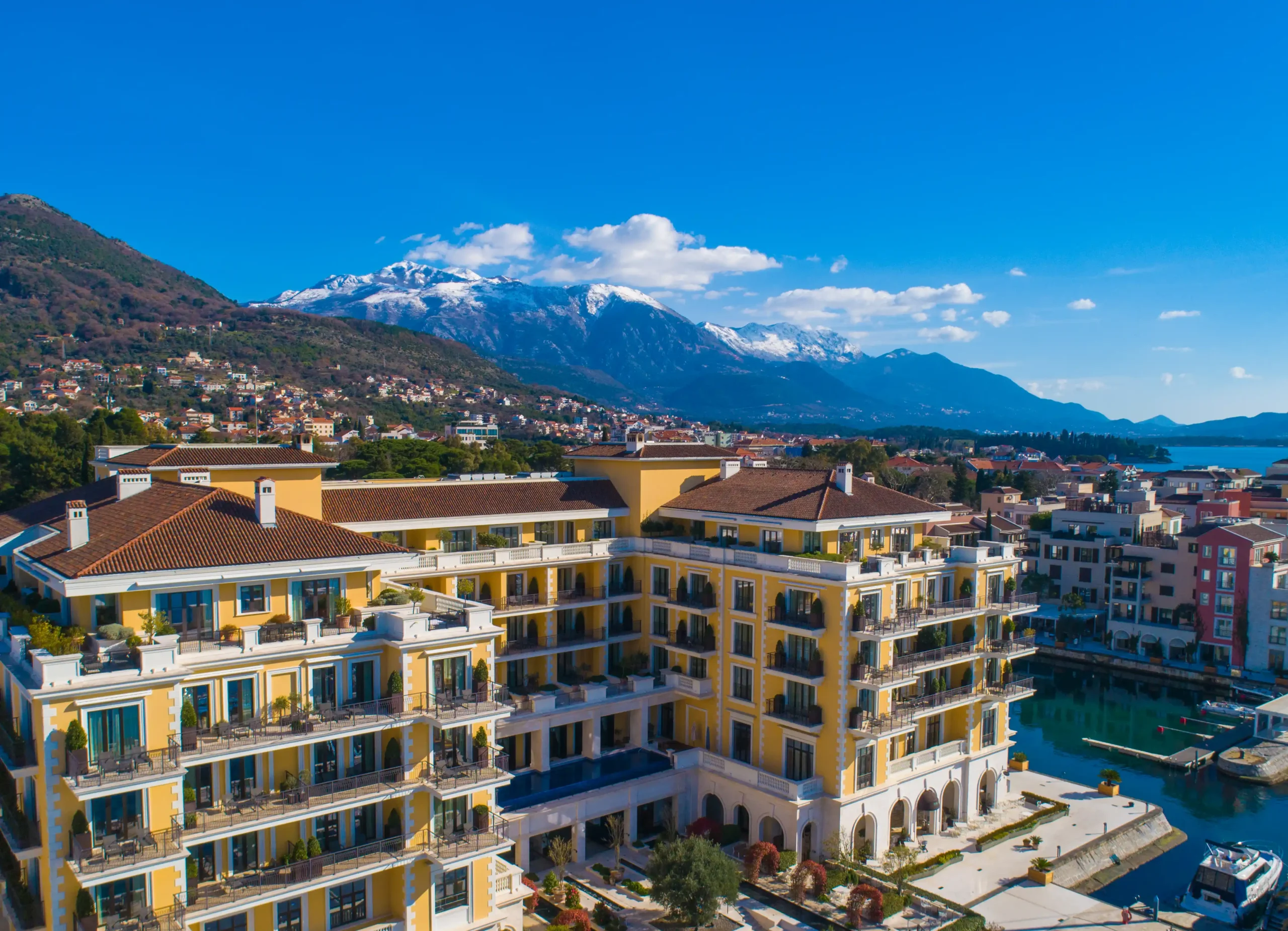 Vista aérea da fachada do Regent Porto Montenegro com as montanhas de Montenegro ao fundo