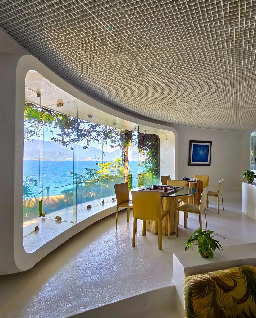 Sala de jantar com painel de vidro e vista para o mar