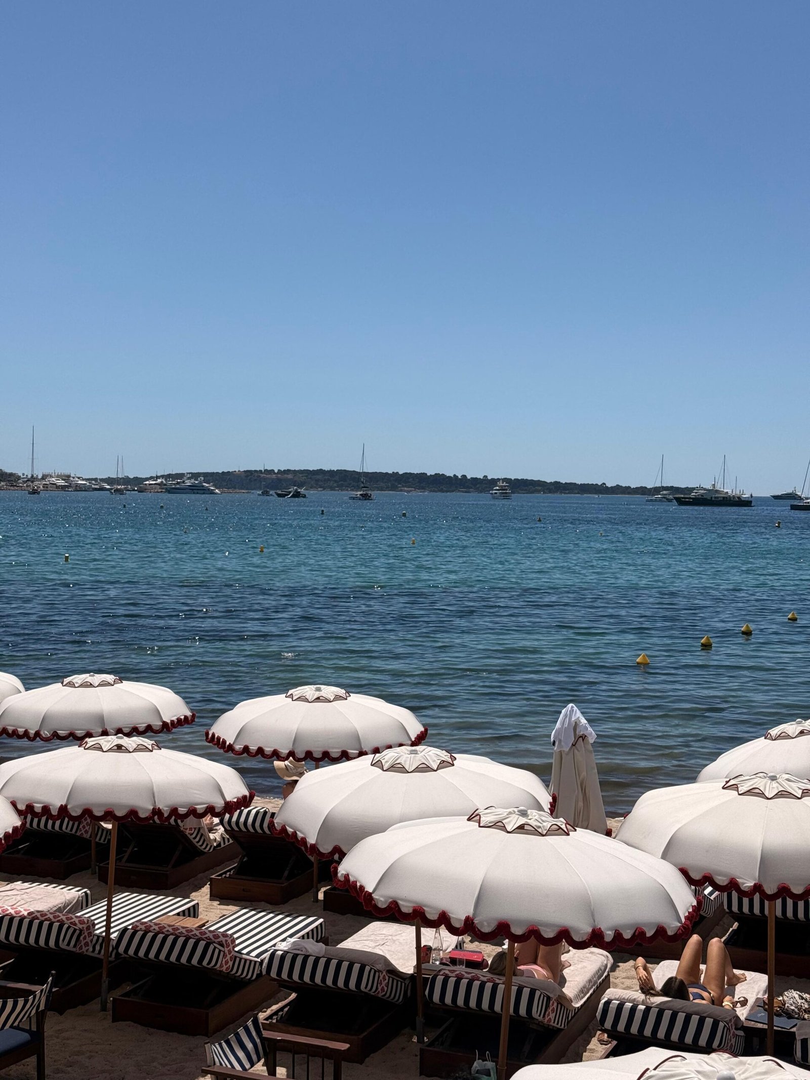 Guarda-sóis brancos na praia em frente ao mar em Cannes