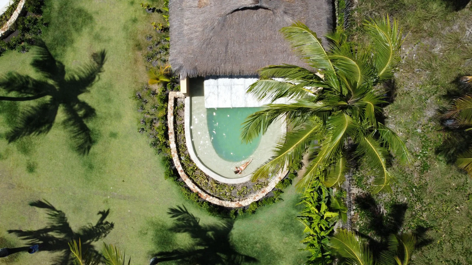 Vista aérea de um bangalô do Primitivo Hotel & Villas com piscina privativa entre coqueiros