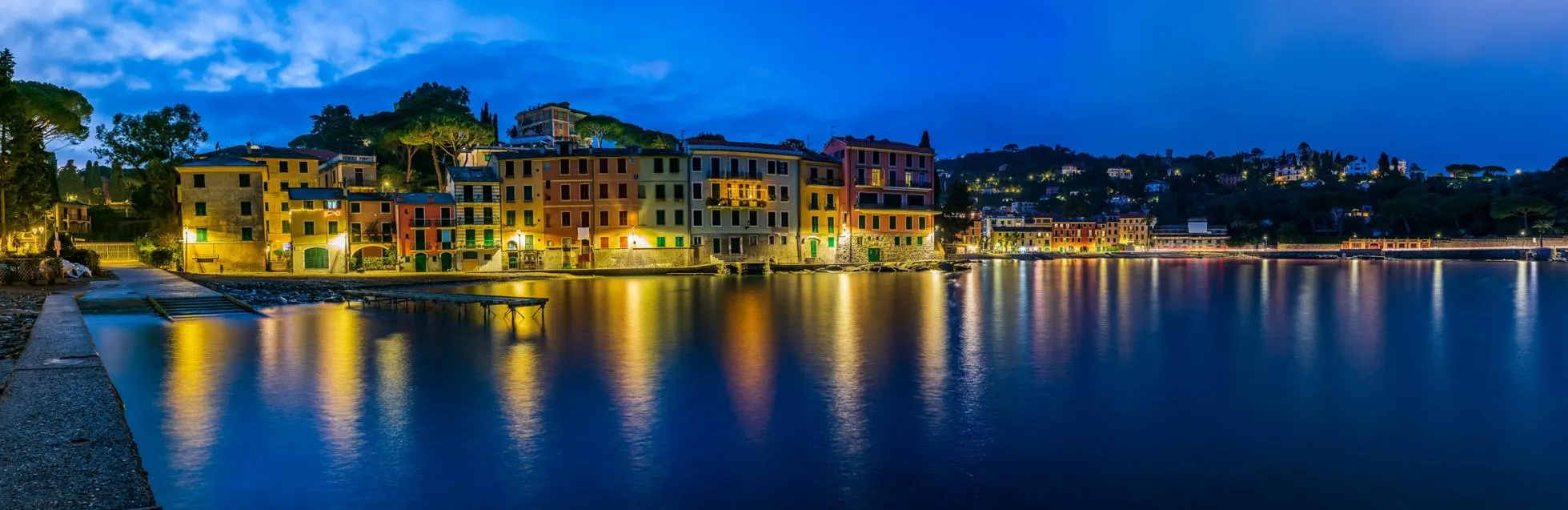 Vista noturna da Riviera Italiana com casas coloridas à beira-mar