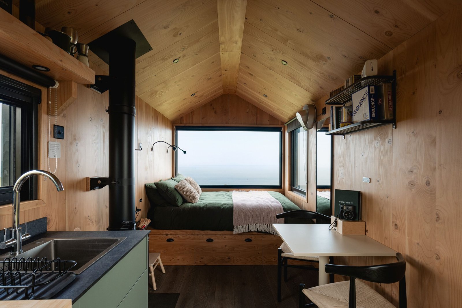 Interior de cabine da Unplugged com lareira e roupa de cama Piglet in Bed