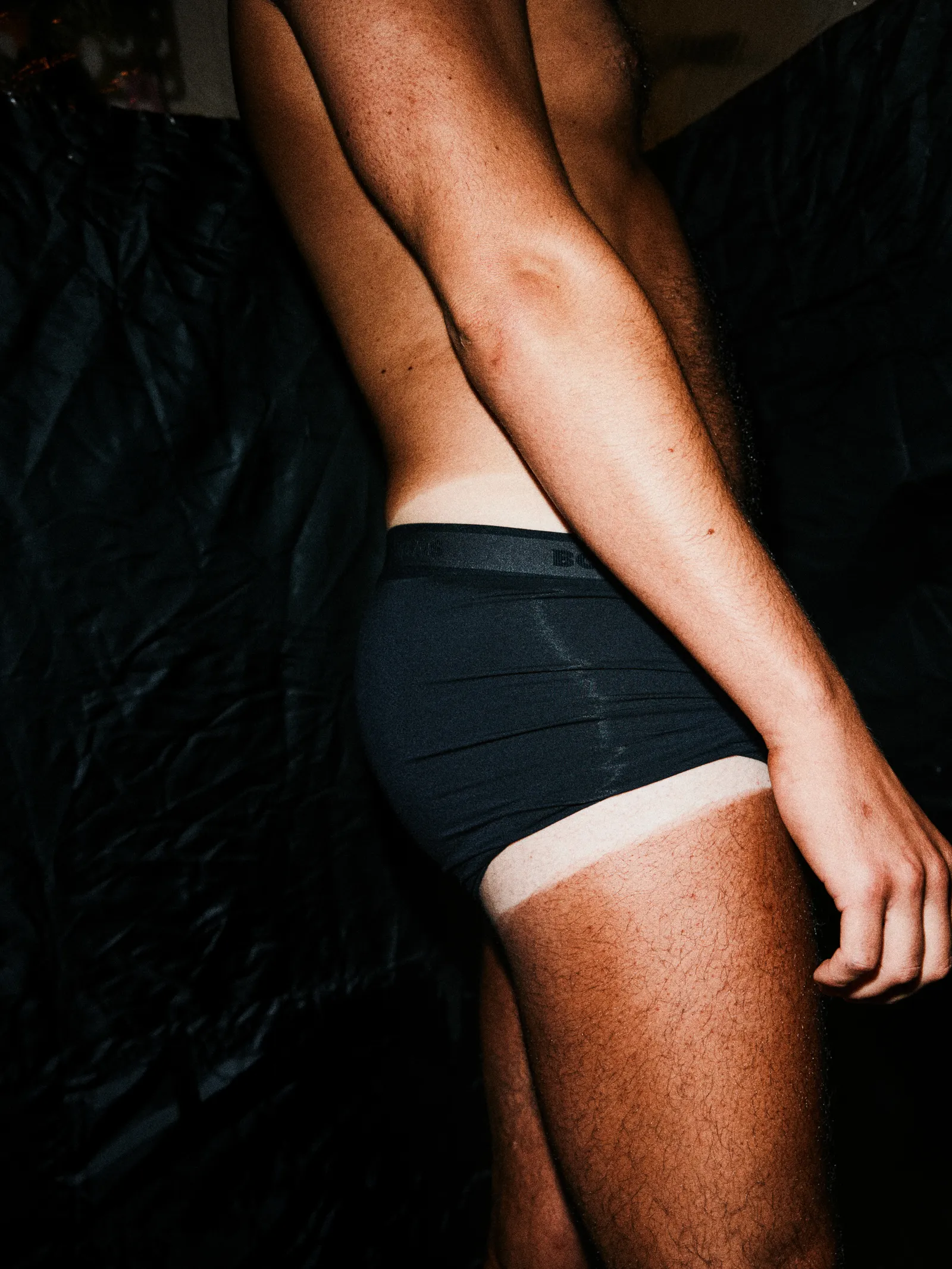 Detalhe de coxa e short com marcas de bronzeado em contraste