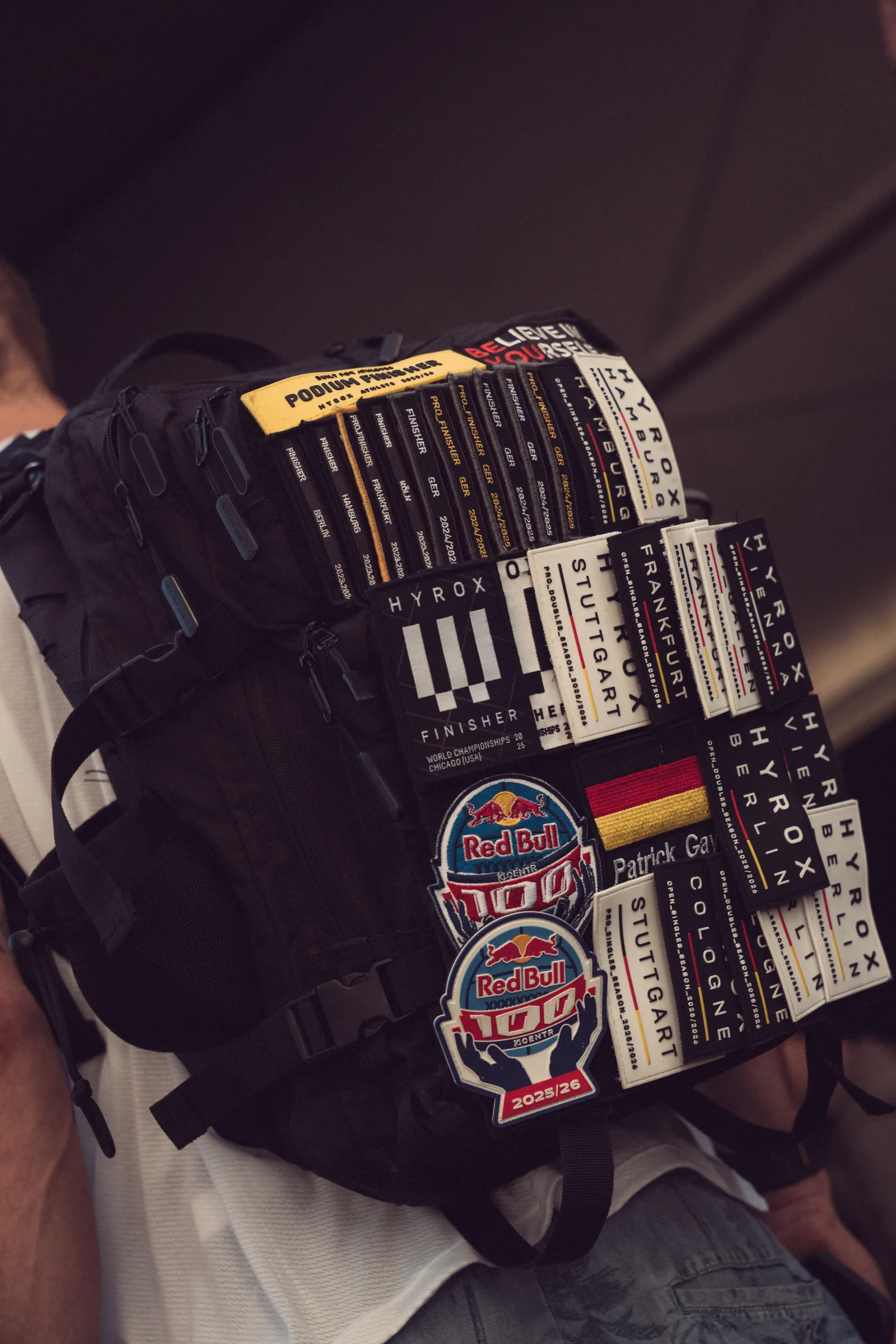 Mochila coberta de emblemas de provas de Hyrox