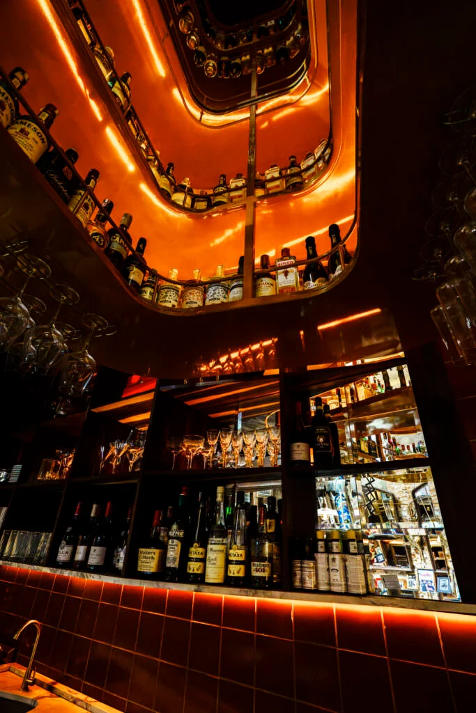 Interior do Holy Tavern com madeira escura e iluminação baixa