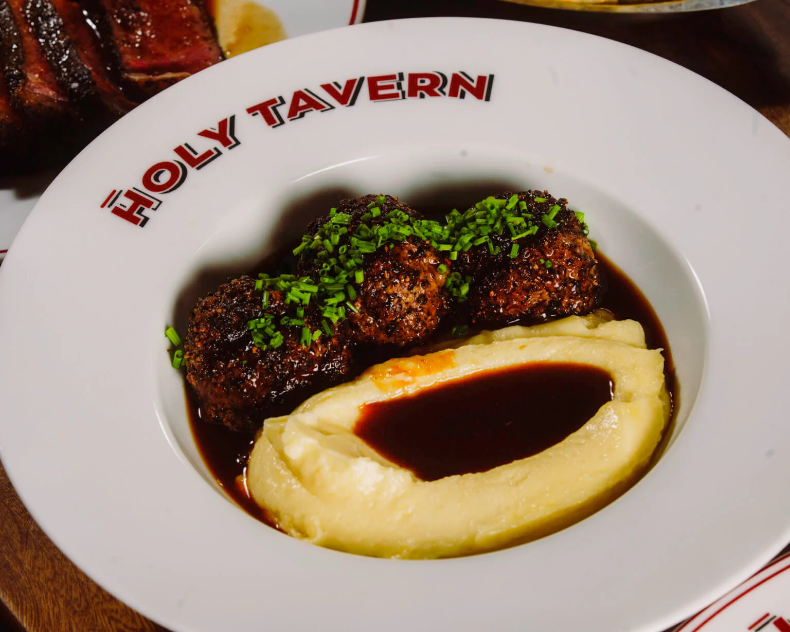 Drinque autoral servido em copo baixo no bar do Holy Tavern