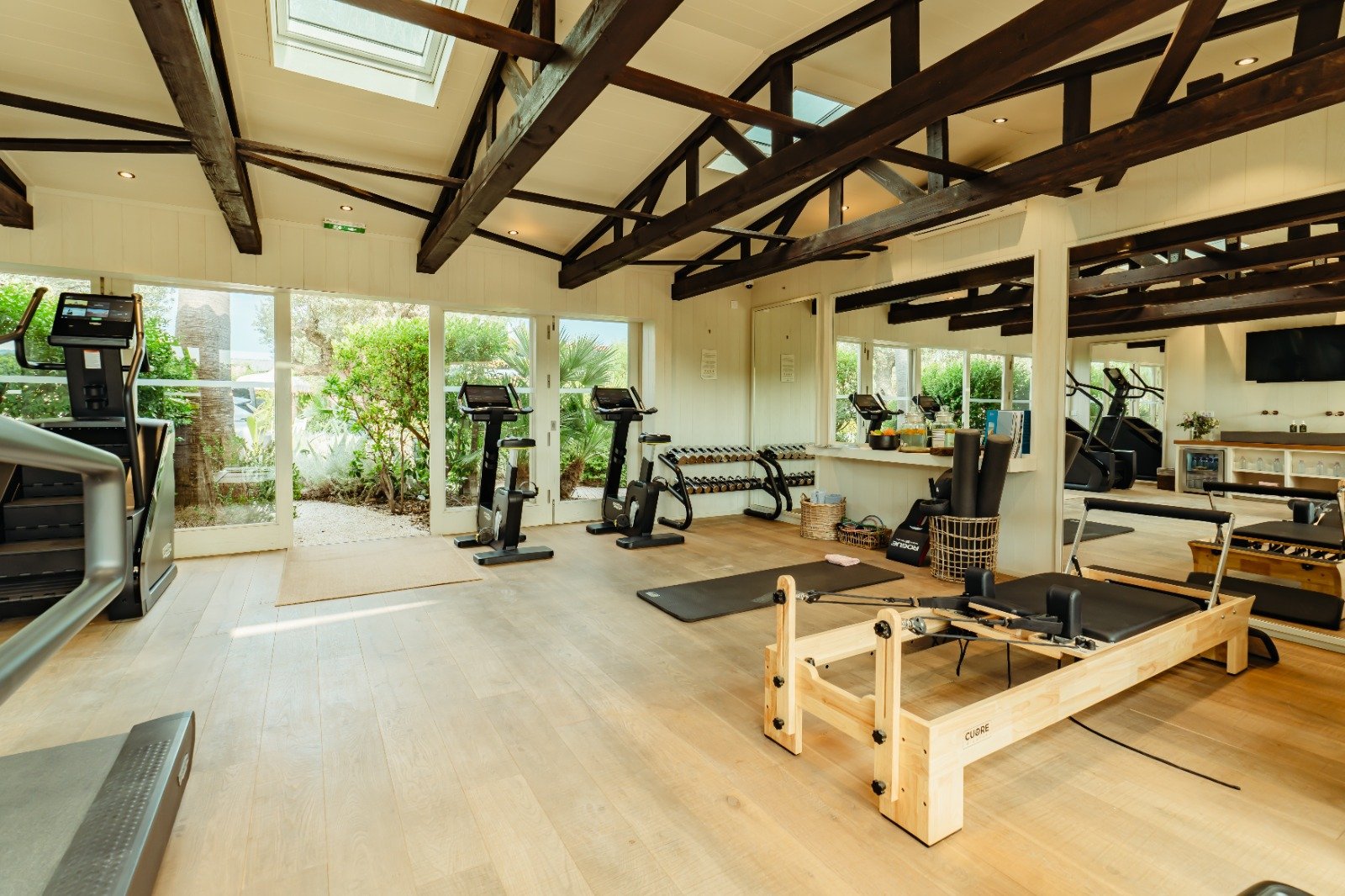 Academia do Épi 1959 com cardio, pesos e Pilates Reformer sob vigas de madeira