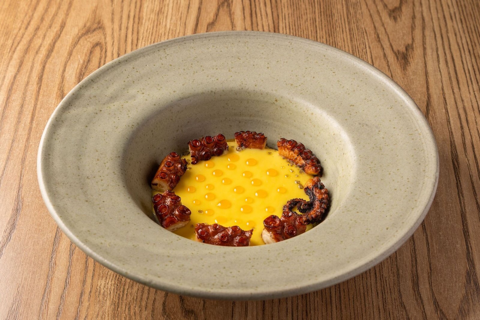 Pulpo Anticuchero do AMA.ZO, polvo grelhado sobre creme amarelo