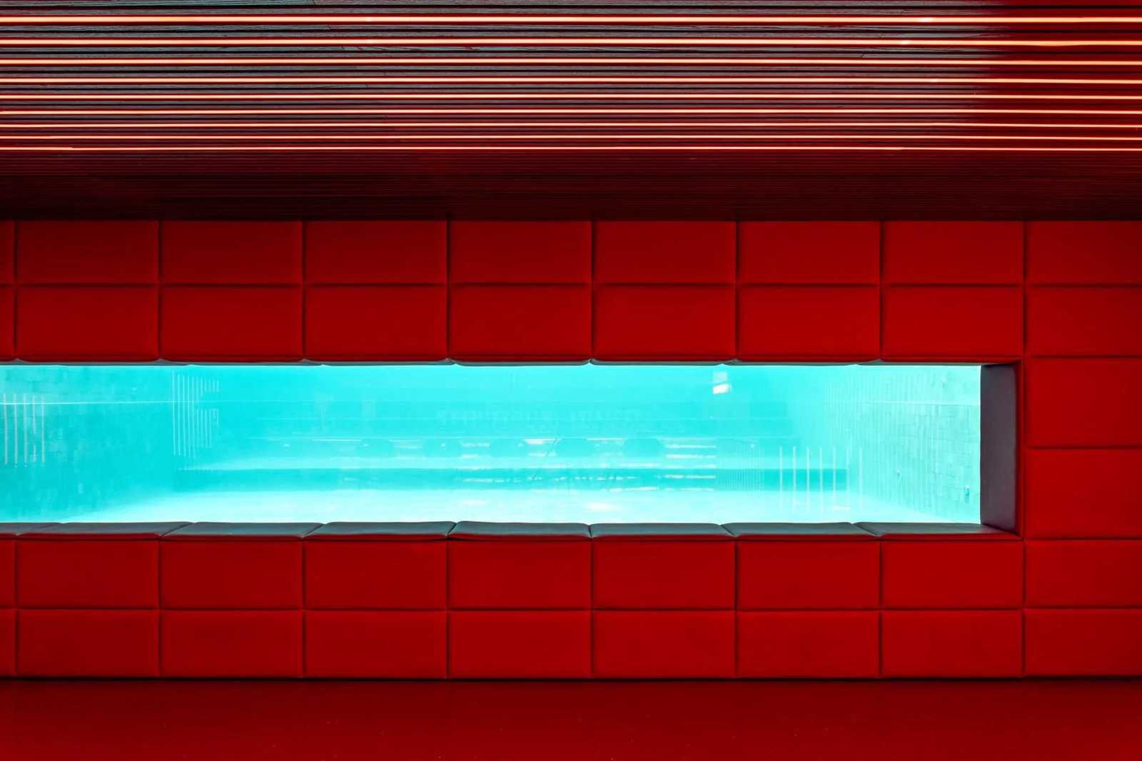 Parede vermelha com visor para o fundo da piscina