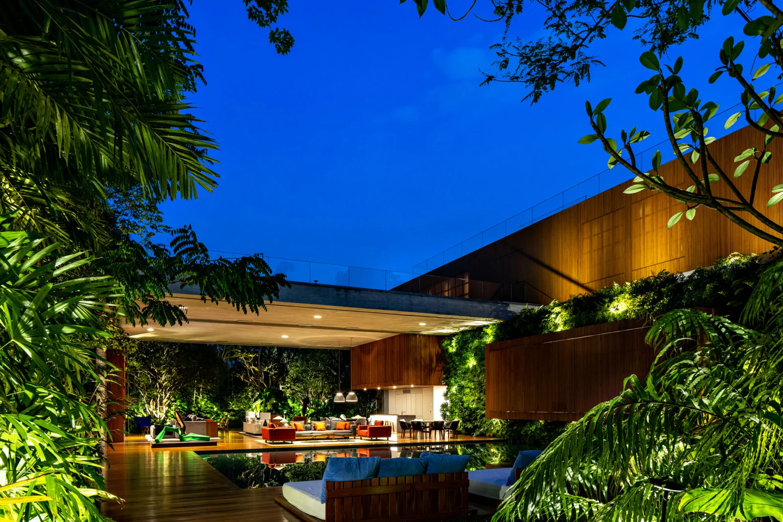 A piscina e o jardim iluminados ao anoitecer