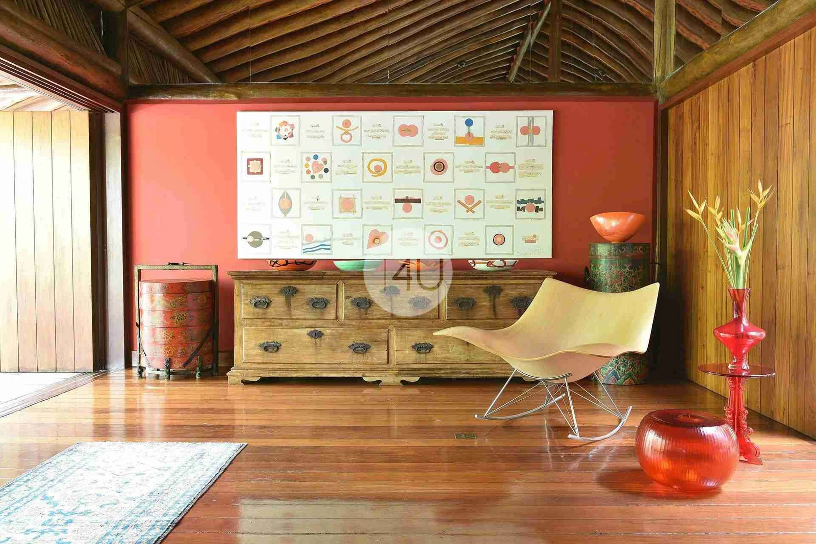Sala com parede terracota, cômoda antiga e obra de arte