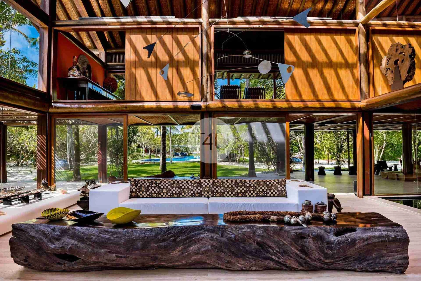 Pavilhão de madeira com telhado aparente e salas abertas para o jardim