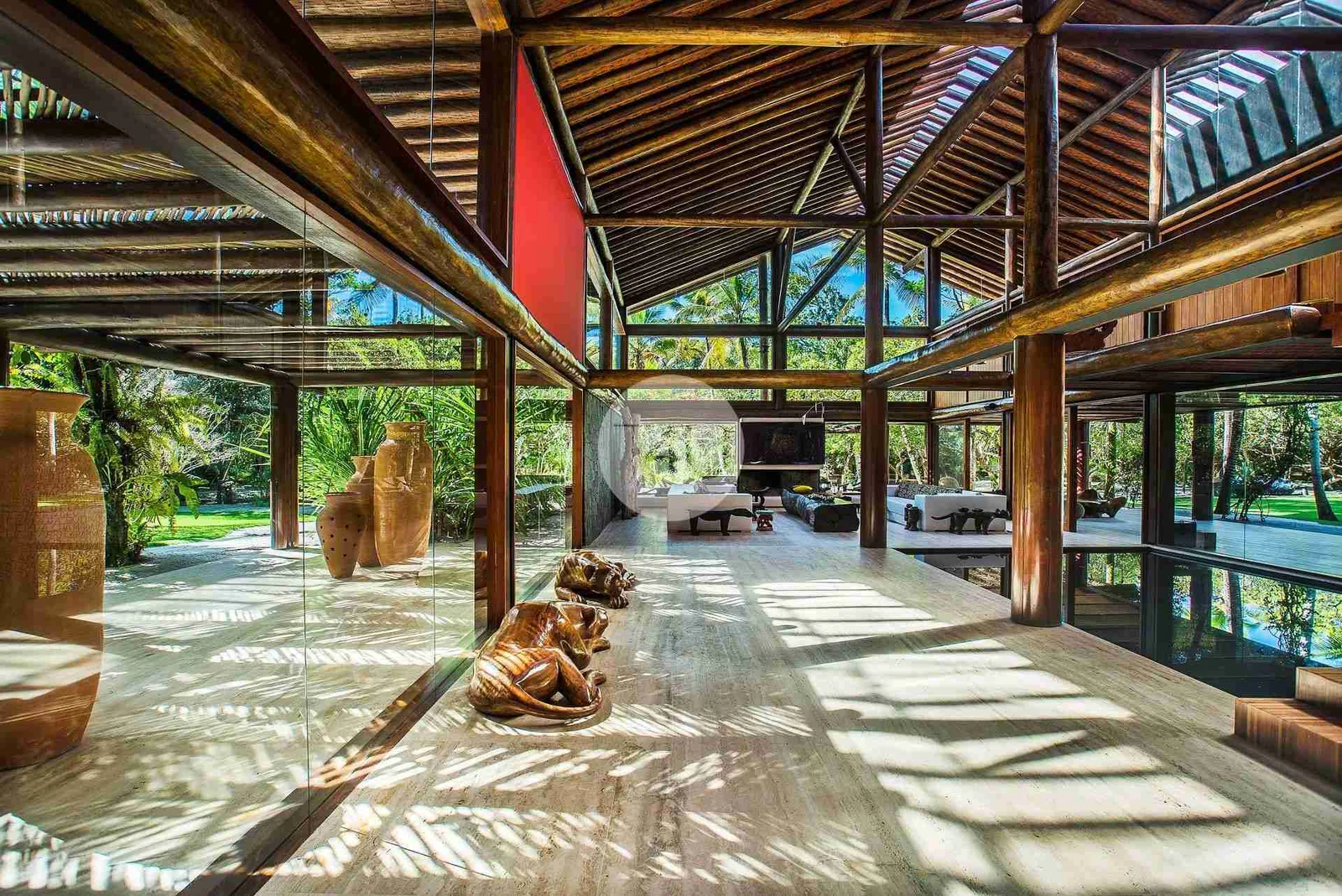 Galeria de madeira aberta, com esculturas e luz filtrada
