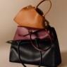 Bolsas Clash de Cartier em caramelo, bordô e preto empilhadas