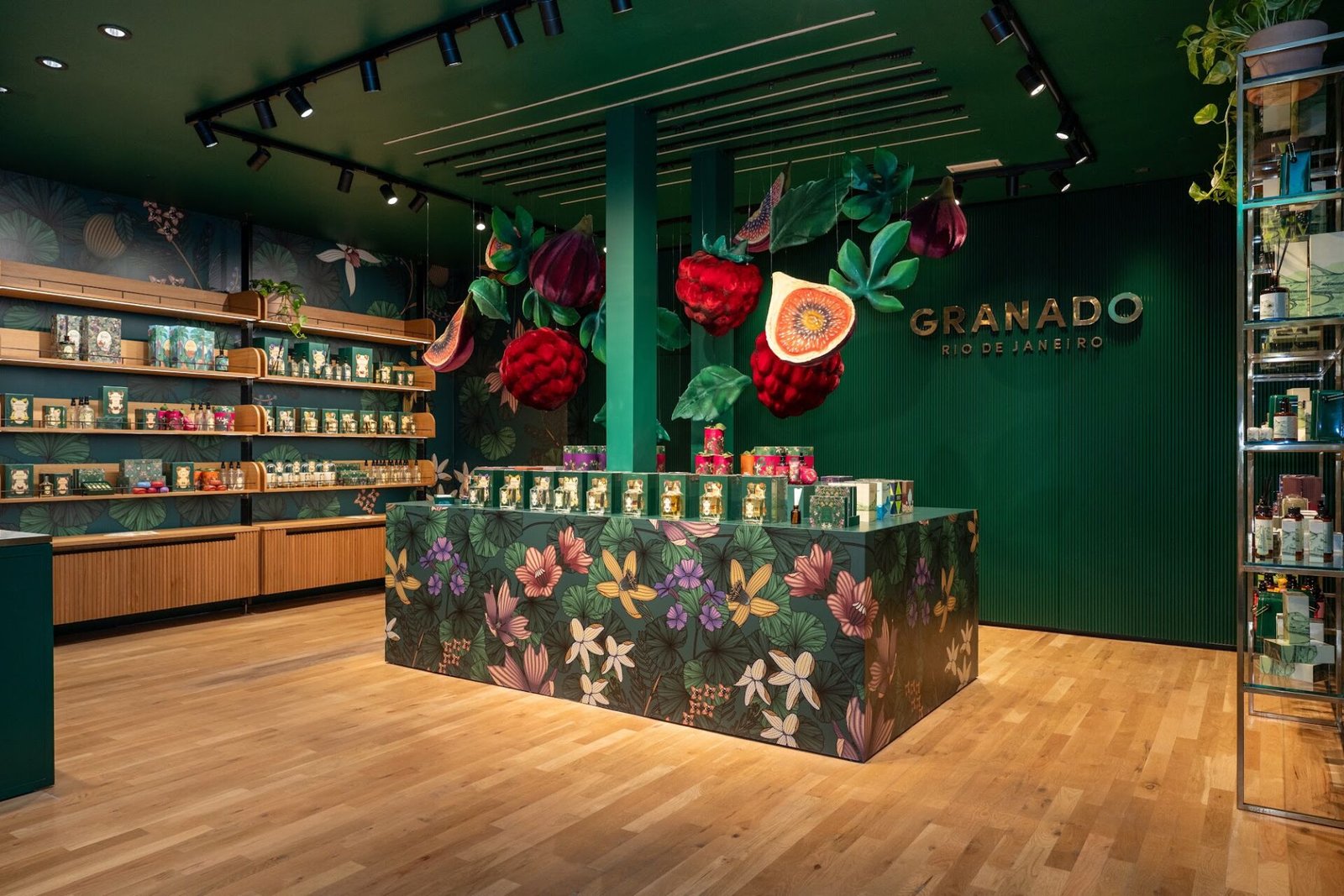 Interior da boutique Granado em Madri, com balcão ilustrado com frutas e flores e prateleiras de perfumaria