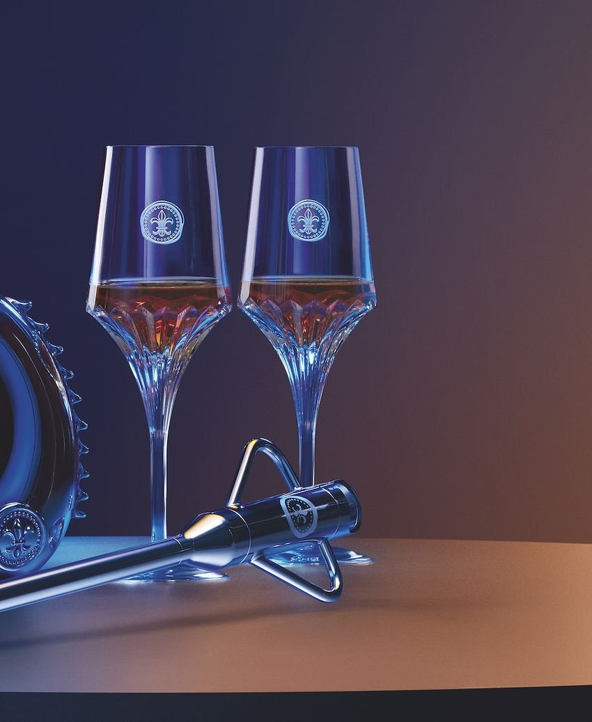 Duas taças de cristal servidas com Cognac ao lado da lança metálica de servir, apoiada em seu suporte.