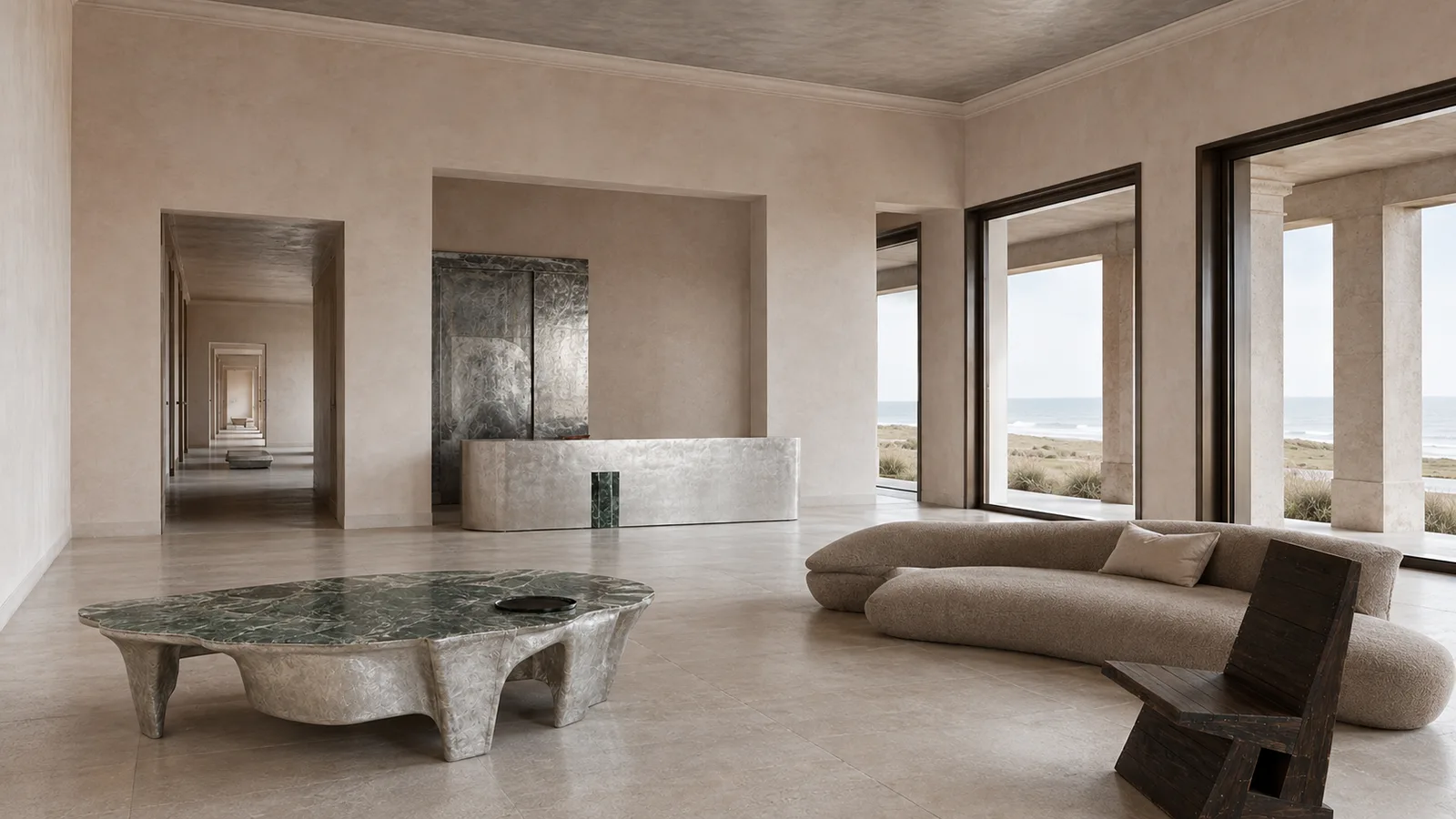Salão com paredes de gesso, mesa de mármore verde e portas altas abertas para o mar
