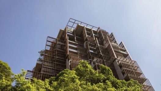 A Torre Mata Atlântica, de Jean Nouvel, vista de baixo, com as treliças de madeira da fachada acima das copas das árvores