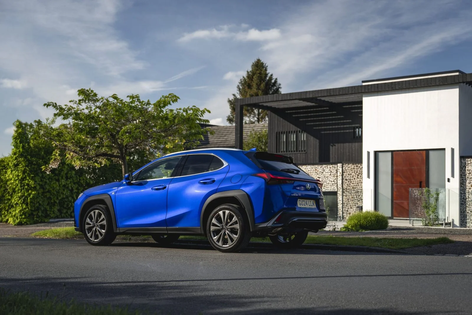 Traseira em três quartos do Lexus UX 300h azul, com lanterna contínua de ponta a ponta.