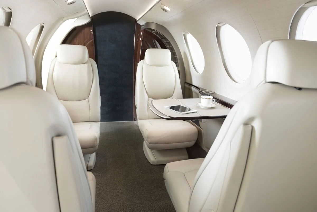 Cabine executiva do Beechcraft Denali com poltronas claras e mesa central