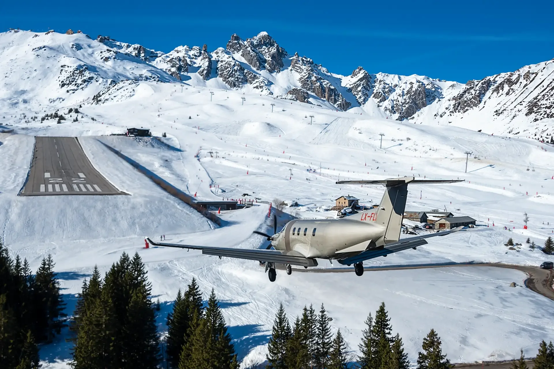 PC-12 na pista inclinada do altiporto de Courchevel, cercada de neve