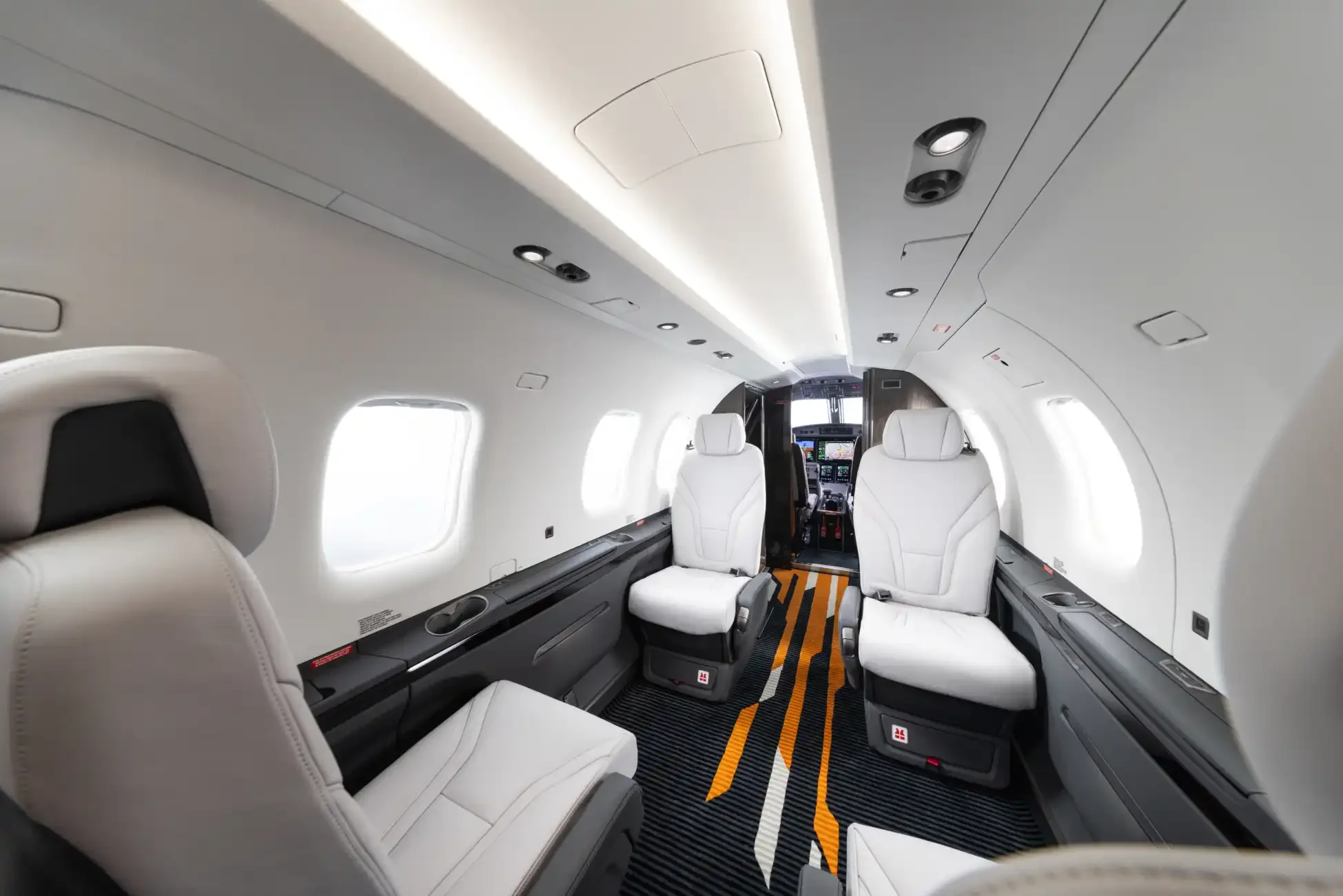 Cabine do Pilatus PC-12 PRO com poltronas executivas claras e corredor central