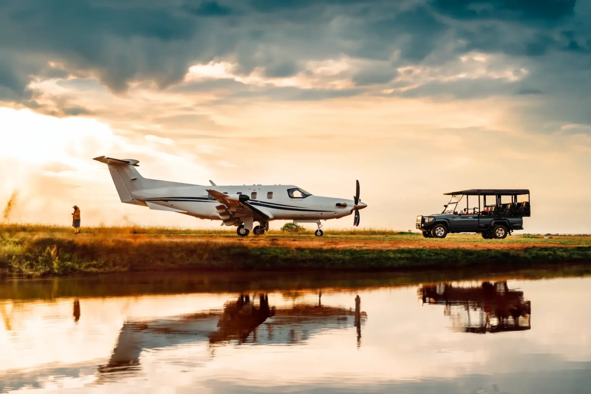 PC-12 PRO estacionado em pista de terra no Quênia, refletido em espelho d’água ao entardecer