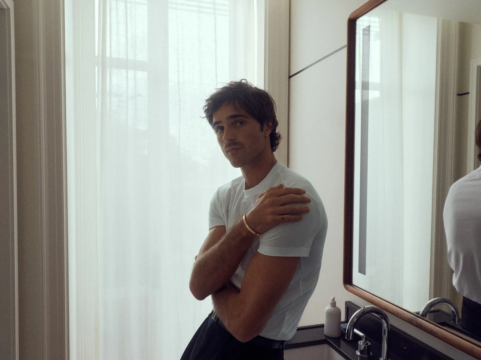 Jacob Elordi diante do espelho com a pulseira LOVE