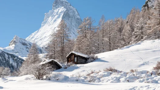 Chalés de Zermatt na neve com o Matterhorn ao fundo