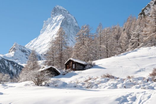 Chalés de Zermatt na neve com o Matterhorn ao fundo