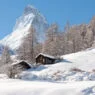 Chalés de Zermatt na neve com o Matterhorn ao fundo