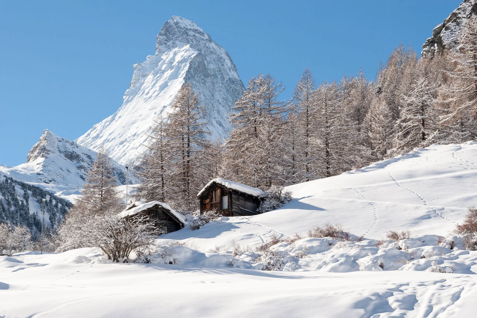 Chalés de Zermatt na neve com o Matterhorn ao fundo