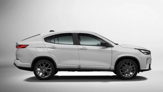 Perfil lateral do Fiat Fastback Impetus MHEV branco em estúdio, com a linha de teto descendo em curva contínua até a tampa do porta-malas e rodas de 18 polegadas escurecidas.