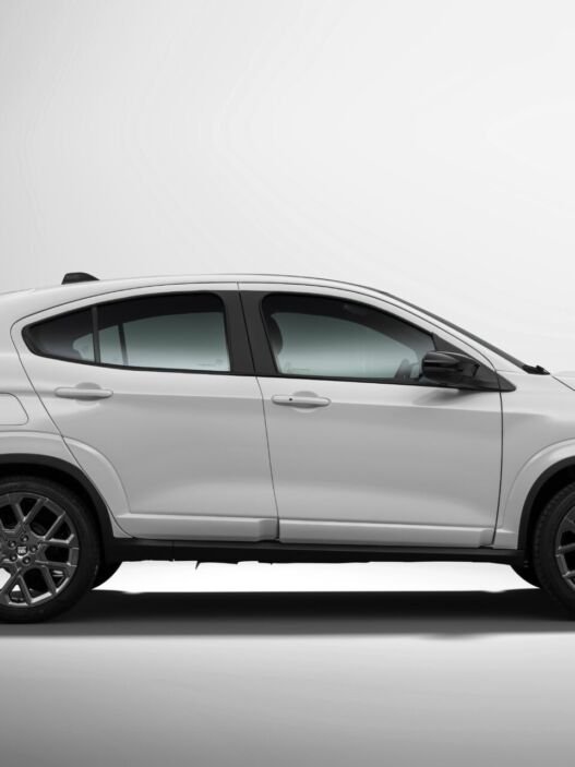 Perfil lateral do Fiat Fastback Impetus MHEV branco em estúdio, com a linha de teto descendo em curva contínua até a tampa do porta-malas e rodas de 18 polegadas escurecidas.