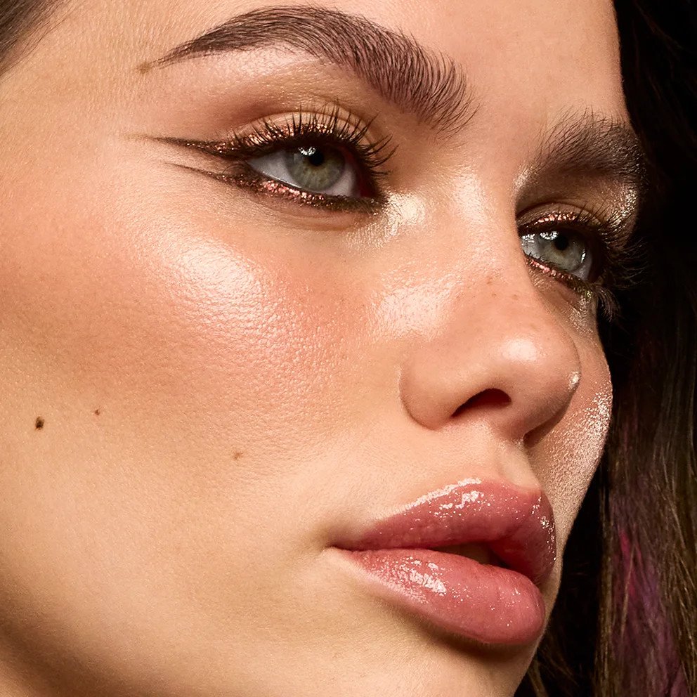 Modelo com olhos em tons de cobre e lábios com gloss na campanha Just Cavalli x KIKO Milano