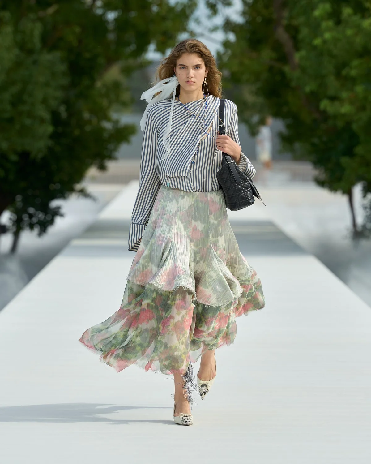 Look 8 de Dior Verão 2027, camisa listrada azul e branca com saia floral em camadas