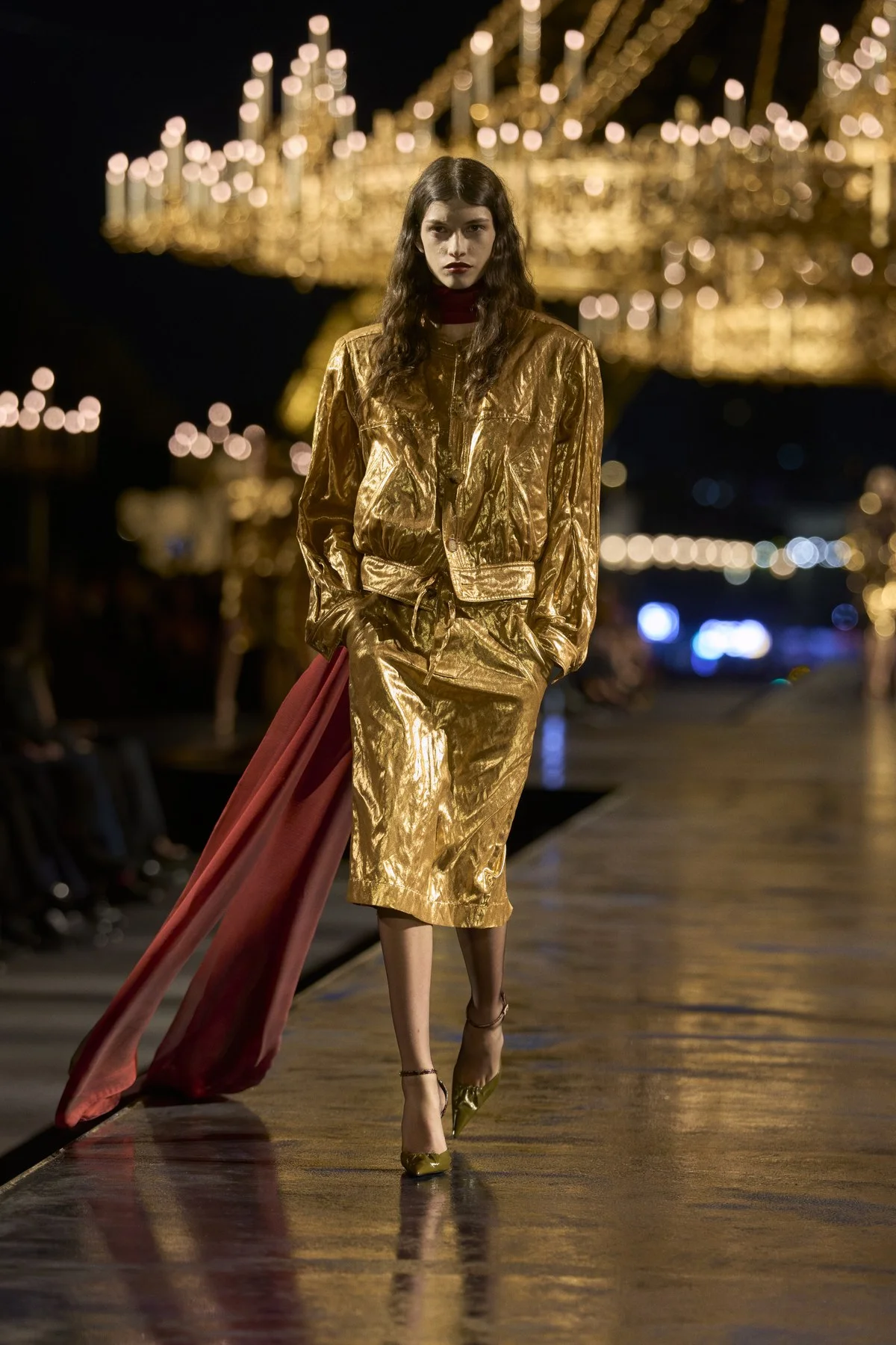 Look de Saint Laurent Verão 2027 com jaqueta curta e saia lápis douradas e drapeado vermelho