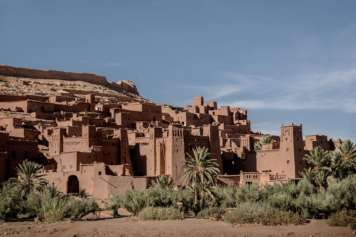 Construções de pisé em Ait Benhaddou com palmeiras ao pé da colina